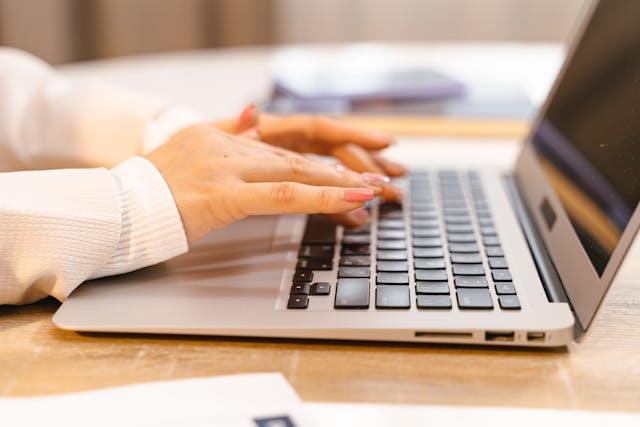 a person typing on a laptop at a desk